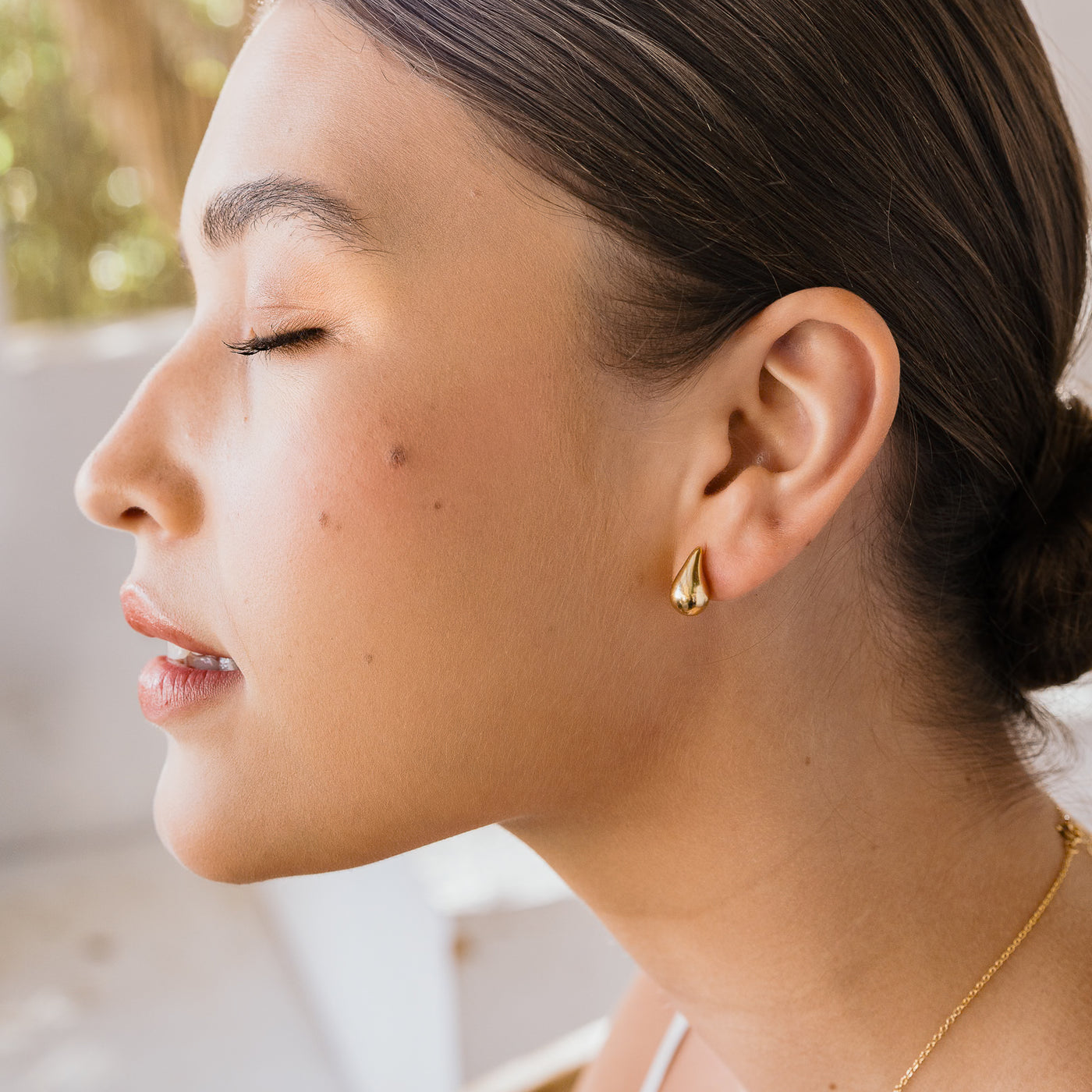 Large Teardrop Stud Earrings. Woman in profile with her eyes closed, wearing teardrop stud earrings.