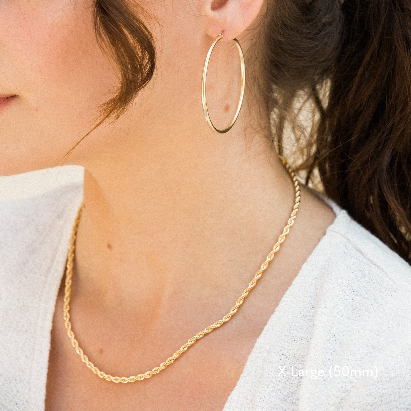 Woman wearing a single extra large 50mm gold Everyday Hoop Earring on one ear. The photo is taken from the side, showing her earring and neck with a gold rope chain.

Small (13mm) Medium (22mm) Large (35mm) X-Large (50mm), Everyday Hoop Earrings by Simple & Dainty Jewelry