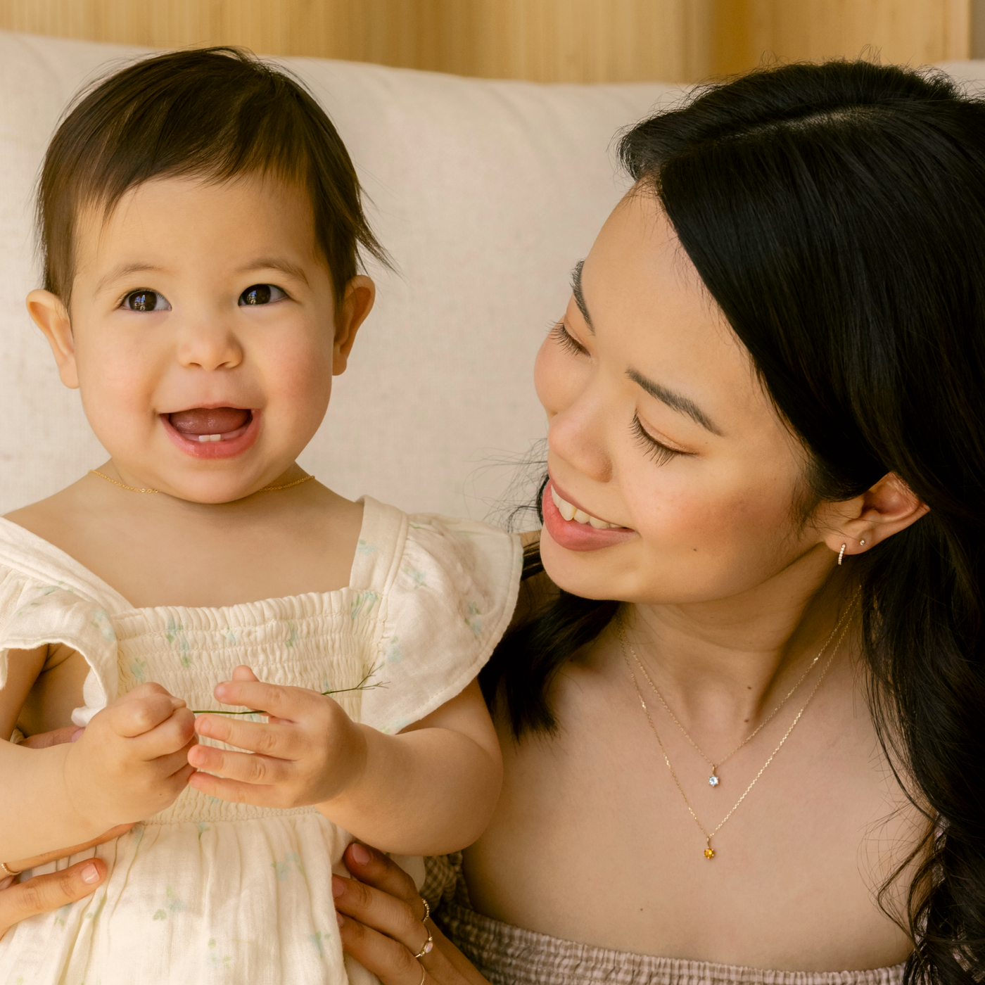 Woman and child in light clothing sitting together.  January - Garnet February - Amethyst March - Aquamarine April - White Topaz April - Diamond May - Emerald June - Pearl June - Moonstone July - Ruby August - Peridot September - Sapphire October - Australian Opal October - Pink Tourmaline November - Citrine December - Tanzanite 14k Birthstone Charm Necklace